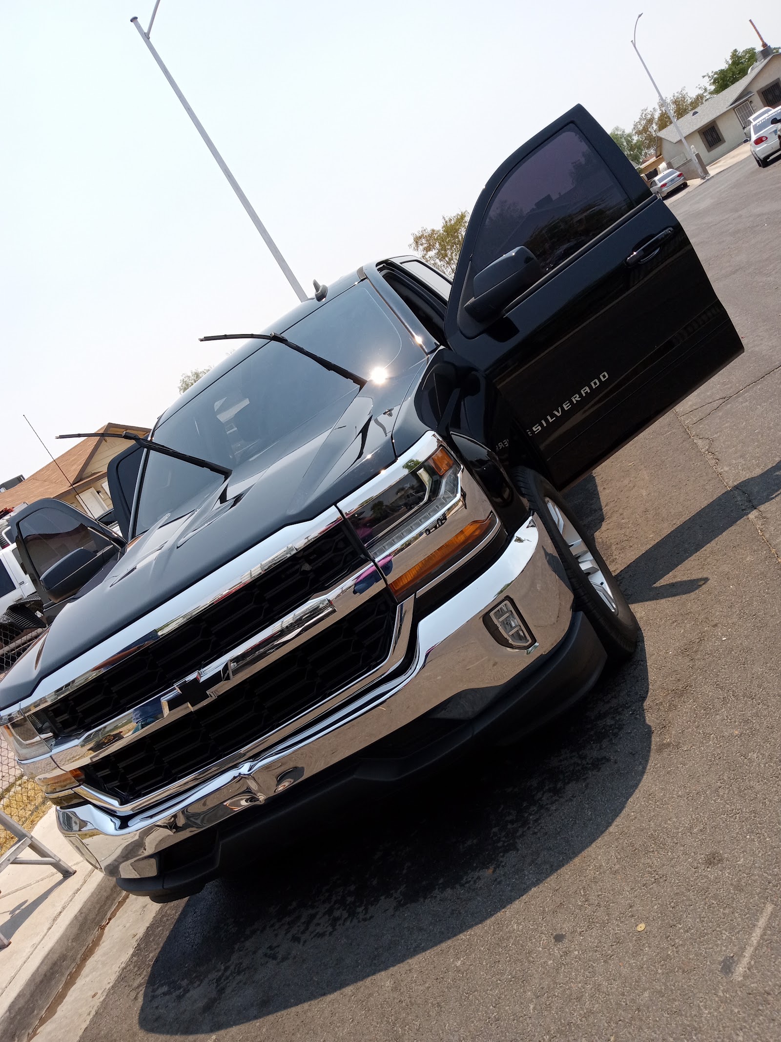 Freshly detailed dark Chevy Silverado with a door open outdoors