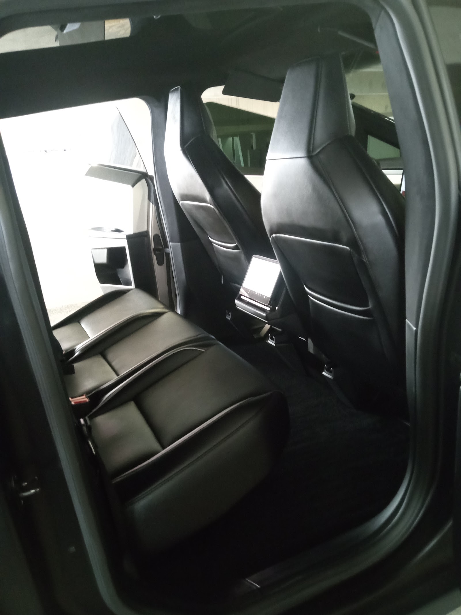 Clean black leather rear seats and interior of a vehicle after detailing